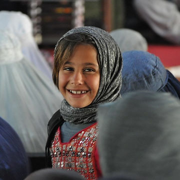 A young child wearing a head scarf
Description automatically generated